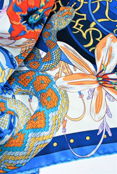 a blue and orange scarf with dragon designs on it