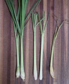 three stalks of celery sitting on top of a wooden table