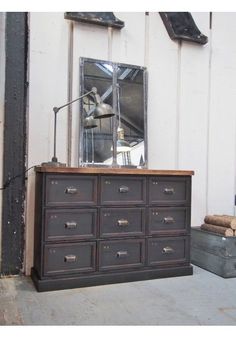 an old dresser is next to a large mirror