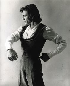 black and white photograph of a man in overalls with his hands on his hips