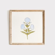 a painting with blue flowers in a wooden frame on a white wall next to a plant