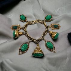 This Glamorous Piece features Ornate Gilt Gold tone Metal with faux Glass Jade Green Cabochons adorned with faux Pearls. The links have scrollwork on some. There is no signature on this bracelet, light wear on some of the gold tone but nothing that is very noticeable. Bracelet measures 7 ½" long by 1 ½" wide. Vintage Metal Charm Bracelet, Retro Metal Jewelry, Vintage Jeweled Bracelets For Party, Vintage Green Jeweled Jewelry, Vintage Metal Bracelets For Evening, Vintage Metal Bracelets For Evening Wear, Vintage Green Bracelets For Party, Retro Vintage Charm Jewelry For Party, Vintage Cabochon Bracelets