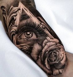 an eye and rose tattoo on the arm