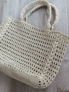 a crocheted bag sitting on top of a wooden floor