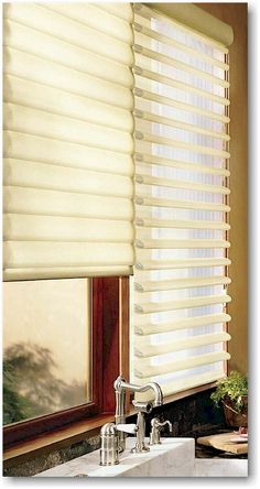 a bathroom window covered in white blinds next to a faucet with a sink