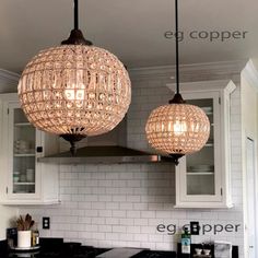 two chandeliers hanging from the ceiling in a kitchen