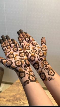 two hands with henna designs on them