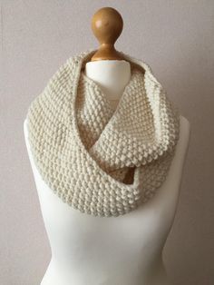 a white knitted scarf on top of a mannequin head with text overlay reading seed stitch infinity scarf