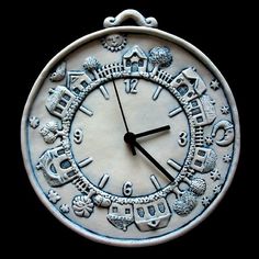 a white clock with black numbers and symbols on it's face is shown in front of a black background