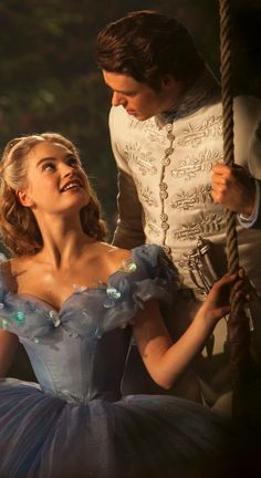 the young man and woman are dressed up as cinderella and prince charmingly swing on a rope