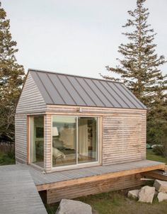 a small wooden cabin sitting on top of a grass covered field