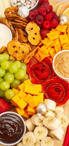 a wooden platter filled with fruit and snacks