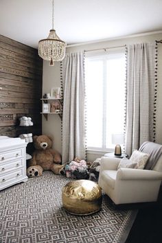 a living room filled with furniture and a baby's crib next to a window