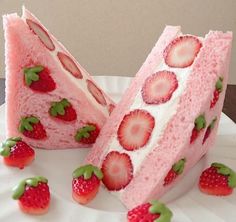 there are strawberries on the cake and one is cut in half