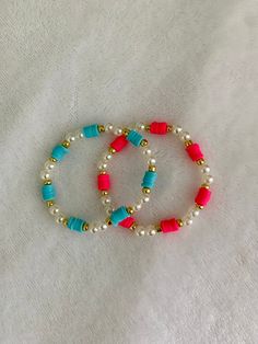 two beaded bracelets on a white sheet