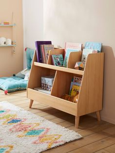 a wooden book shelf with books on it in a child's playroom area