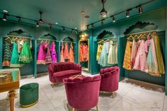 a room filled with lots of different colored chairs and dresses hanging on the wall in front of them