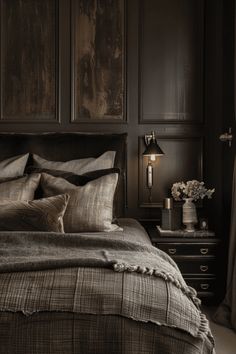 a bedroom with dark wood paneled walls and bedding