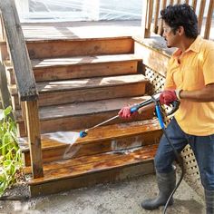 a man using a pressure washer to clean wooden steps