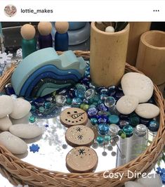 a basket filled with lots of different types of rocks and glass beads on top of a table