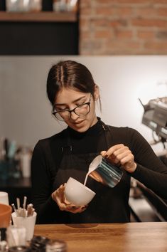 a woman pours coffee into a cup