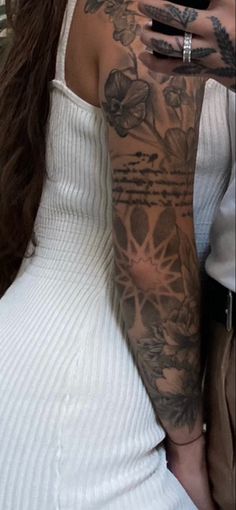 a woman with tattoos on her arm taking a selfie