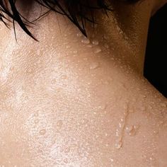 the back of a woman's neck with water drops on it