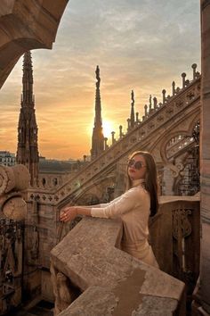 a woman standing on top of a stone building