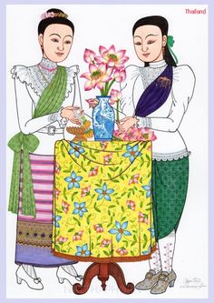 two people standing next to each other at a table with flowers in a vase on it