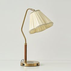 a table lamp with a wooden base and a white shade on the top is shown