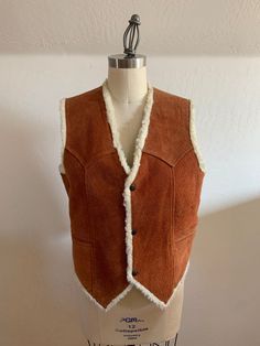 Classic western suede vest with western yoke in back and front, 2 welt pockets, and three front snaps. The suede has some wear on it but in my opinion that only makes it cooler, see photos. Overall, it's in great shape! I can't read the label.  Laid flat it measures- Shoulder 15" Pit to pit 21" Waist 21" Length 25" Please ask any questions prior to purchase and see all photos, all sales are final, thank you! Brown Sleeveless Vest For Western-themed Events, Western Style Vest With Pockets For Fall, Western Rodeo Vest, Western Style Sleeveless Vest For Rodeo, Sleeveless Western Outerwear For Fall, Western Style Brown Vest For Western-themed Events, Brown Western Vest For Western-themed Events, Winter Sleeveless Vest With Snap Buttons, Sleeveless Western Winter Outerwear