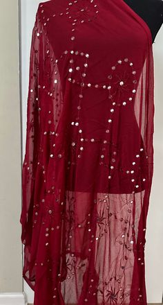 This unique Maroon Dupatta is an excellent addition to any wardrobe. Its intricate mirror detailing adds a touch of glamour to any outfit. Crafted from fine fabric, it is sure to elevate any look. Dry Clean only. Unstitched Evening Blouse Piece With Mirror Work, Bohemian Embellished Georgette Dupatta, Semi-stitched Embellished Sequin Fabric, Evening Dupatta With Mirror Work For Eid, Bohemian Blouse Piece With Sheer Dupatta For Festive Occasions, Glamorous Eid Dupatta With Mirror Work, Festive Bohemian Blouse With Sheer Dupatta, Glamorous Embellished Festive Dupatta, Glamorous Festive Dupatta With Resham Embroidery