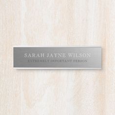 a metal name plate mounted on a wooden wall that says,'sarah jayne wilson extremely important person '