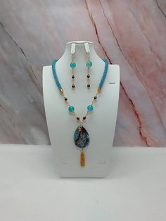 "Handmade and designed by me-one of a kind necklace set-rainbow turquoise seed bead crocheted rope necklace-23\" long-4\" long focal with a fire agate pendant bead and a 1 1/2\"  long chain tassel-brown glass pearls-glass beads-metal beads-2 3/4\" long matching dangle earrings- -gold tone findings-hook and eye clasp. This is a beautiful and unique necklace set! Has a hook and eye clasp so it is easy to put on!" Turquoise Teardrop Jewelry With Beaded Chain, Turquoise Teardrop Beaded Chain Jewelry, Turquoise Teardrop Beaded Jewelry, Turquoise Czech Glass Beaded Chain Jewelry, Turquoise Beaded Chain Costume Jewelry, Turquoise Dangling Beads Czech Glass Jewelry, Turquoise Czech Glass Jewelry With Dangling Beads, Handmade Multicolor Lariat Jewelry, Handmade Turquoise Lariat Jewelry