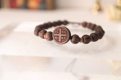 "The ICXC NIKA Orthodox Wooden Adjustable Bracelet, a stylish and meaningful accessory that embodies the spirit of Orthodox Christianity. This exquisite bracelet features high-quality wooden beads , forming a beautiful and meaningful design. The ICXC NIKA emblem, which represents the Greek phrase \"Jesus Christ Conquers,\" is prominently displayed as a center piece  (in both sides), adding a spiritual touch to the bracelet.  What sets this bracelet apart is its adjustable design, allowing for a comfortable fit on any wrist size. The sliding knot mechanism enables easy and secure adjustment, ensuring that the bracelet stays in place during daily activities. Whether you have a small or large wrist, this bracelet can be easily customized to fit you perfectly. Material made of wooden Color: Br Spiritual Cross Bracelets As Gifts, Spiritual Style Cross Beaded Bracelets For Gift, Spiritual Cross Beaded Bracelets As Gift, Spiritual Cross Beaded Bracelets For A Gift, Handmade Brown Rosary Bracelet As Gift, Brown Cross Bracelet Spiritual Style, Spiritual Brown Cross Bracelet, Greek Phrases, Meaningful Design