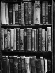 black and white photograph of old books on a book shelf in a library or museum