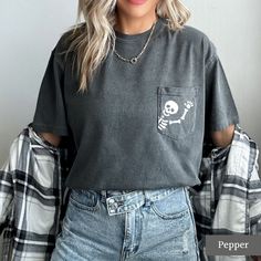 Looking for a cute halloween or fall shirt? You've come to the right place! These cute skeleton pocket tees are a great choice if you're going trick or treating or celebrating spooky season! Our unisex tees are very cute and comfy! You can pair them with your favourite leggings, tuck them into your jeans, or tie them up in a knot. We love this casual style and know you will too! MATERIALS AND SIZING These unisex tees are made with 100% soft cotton and excellent quality print. They fit nice and l Fall Crew Neck T-shirt With Pockets, Cute Fall Tops With Pockets, Casual Skull T-shirt For Fall, Cute Crew Neck Top With Pockets, Edgy Fall Tops With Pockets, Edgy Tops With Pockets For Fall, Trendy Crew Neck T-shirt With Pockets, Halloween Party Outfit, Skeleton Tshirt