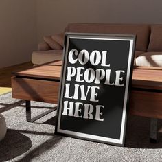 a black and white sign sitting on top of a wooden table next to a couch