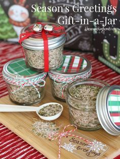 three jars filled with spices on top of a wooden cutting board next to a christmas card