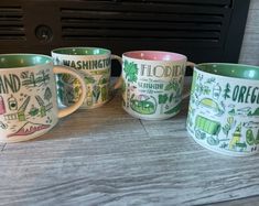 four coffee mugs with different designs on them