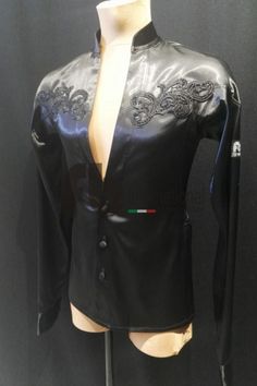 a mannequin wearing a black leather jacket with laces on the collar and sleeves