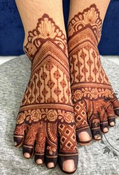 the feet and hands of a woman with henna tattoos