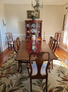 a dining room table with chairs and a china cabinet