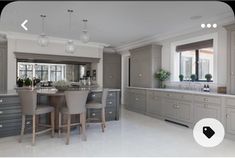 a large kitchen with gray cabinets and marble counter tops