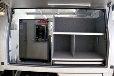 the back end of an rv with its doors open and shelves in place for storage