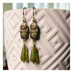 This ornate, vintage inspired design is beautifully detailed and feminine.  I paired these romantic, floral drops with elongated teardrop glass beads. They add the perfect touch of elegance. Beads are Sage green Czech Picasso glass.  Hanging just a touch over 2 inches, (including ear wires). ~ Eleanor ~ Perfect for those who love unique, vintage style.  These earrings are professionally stamped and Antique Gold plated in the USA and finished with my handmade 14k gold-filled ear wires (French Sty Vintage Brass Teardrop Earrings, Elegant Czech Glass Teardrop Earrings, Elegant Nickel-free Czech Glass Teardrop Earrings, Handmade Ornate Teardrop Earrings, Elegant Czech Glass Drop Jewelry, Vintage Teardrop Earrings As A Gift, Vintage Teardrop Jewelry With Intricate Design, Gold Art Deco, Art Nouveau Style