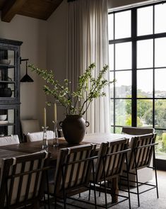 a dining room table with chairs and a vase on it