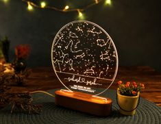 a night light with stars on it sitting next to a potted plant