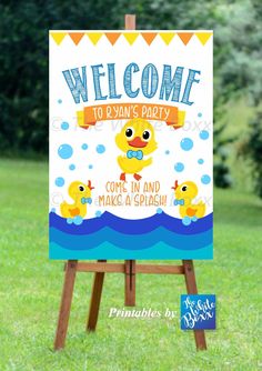 a welcome sign in the grass with rubber ducks on it and an image of a rubber duck