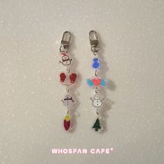 two charms with snowmen and christmas trees hanging from the side of each earring